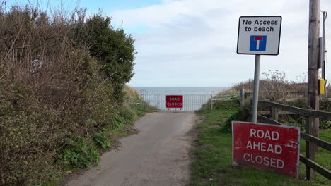 Señales-De-Carretera-Roja-Cerrada-Y-Una-Barrera-Advierten-De-Dónde-La-Erosión-Costera-Ha-Destruido-Una-Carretera-En-La-Costa-De-Norfolk