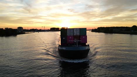 Aerial-View-Off-Forward-Bow-Of-Casa-Blanca-Cargo-Vessel-Travelling-Along-Oude-Maas-With-Golden-Yellow-Sunset-In-Background