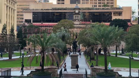 People-and-office-workers-rushing-off,-walking-fast-towards-central-station-across-Anzac-square-at-downtown-Brisbane-city,-Queensland,-Australia