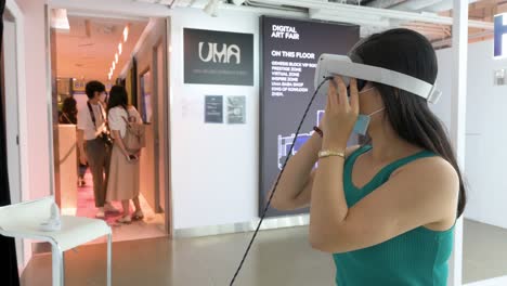 Ein-Chinesischer-Kunstbesucher-Verwendet-Ein-Virtual-Reality-Headset,-Um-Mit-Einem-Immersiven-Kunstwerk-Auf-Der-Digital-Art-Fair-Zu-Interagieren,-Das-Kommende-Trends-Wie-Web-3-Präsentiert