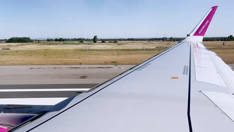 Primera-Parte-Del-Punto-De-Vista-Del-Pasajero-Del-Ala-Del-Avión-Wizzair-Durante-El-Despegue-De-La-Pista-Del-Aeropuerto-De-Roma-Fiumicino,-Italia