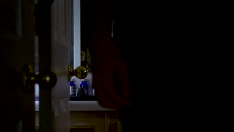 Man-walks-out-of-bathroom-with-beard-oil-bottles-on-the-counter