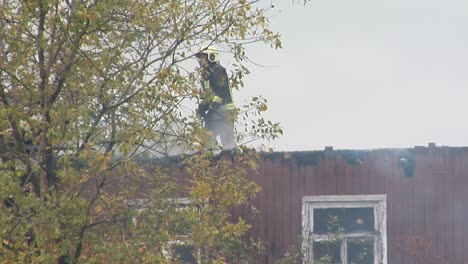 Feuerwehrleute-Richten-Wasserstrahl-Auf-Brennendes-Haus