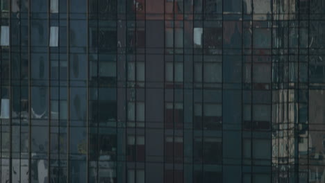 Pan-Up-View-Of-Reflective-Window-Panes-On-Skyscraper-In-New-York