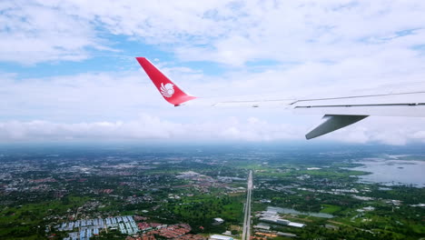 View-the-atmosphere-window-wing-of-a-Thai-Lion-Air-airplane-flight-in-sky-for-travel-transportation-on-holiday-at-Thailand