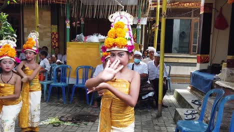 Danza-Balinesa-Rejang-Dewa,-Niñas-Vírgenes-Bailando-En-El-Templo-Ofreciendo-A-Los-Dioses,-Vestidas-Con-Vestidos-Amarillos-Y-Coronas-De-Flores