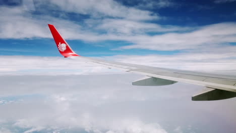 View-the-atmosphere-window-wing-of-a-Thai-Lion-Air-airplane-flight-in-sky-for-travel-transportation-on-holiday-at-Thailand