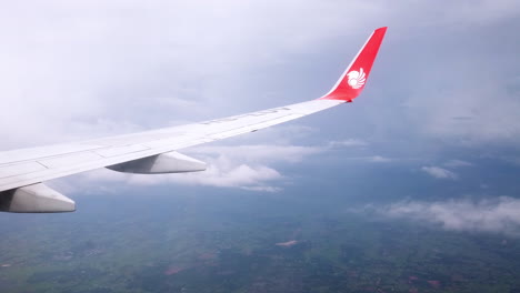 View-the-atmosphere-window-wing-of-a-Thai-Lion-Air-airplane-flight-in-sky-for-travel-transportation-on-holiday-at-Thailand