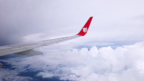 View-the-atmosphere-window-wing-of-a-Thai-Lion-Air-airplane-flight-in-sky-for-travel-transportation-on-holiday-at-Thailand