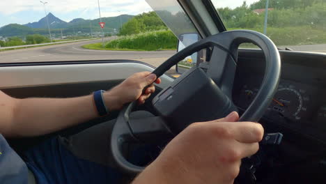 Man-driving-car-and-holding-the-steering-wheel,-while-making-a-turn