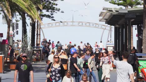 Tiro-Estático-En-El-Punto-De-Acceso-Turístico,-El-Ajetreado-Centro-De-La-Ciudad-De-La-Costa-Dorada-Lleno-De-Gente-Paseando-Por-La-Avenida-Cavill-Con-El-Cartel-Del-Paraíso-De-Los-Surfistas-En-El-Fondo-En-La-Explanada,-Queensland,-Australia