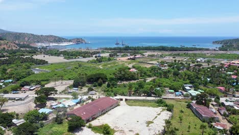 Levantamiento-Aéreo-Sobre-Desarrollos-De-Infraestructura-Portuaria,-Casas-Comunitarias-Locales,-Tráfico-Y-Vistas-Al-Océano-En-Las-Afueras-De-La-Capital-Dili-En-Tibar-Rural,-Timor-Leste,-Sudeste-Asiático