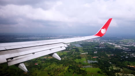 View-the-atmosphere-window-wing-of-a-Thai-Lion-Air-airplane-flight-in-sky-for-travel-transportation-on-holiday-at-Thailand