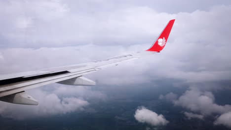 View-the-atmosphere-window-wing-of-a-Thai-Lion-Air-airplane-flight-in-sky-for-travel-transportation-on-holiday-at-Thailand