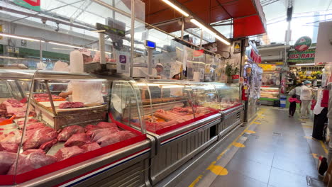 Shot-of-meat-shop-with-locals-walking-by-in-Surco,-Lima,-Peru-at-daytime