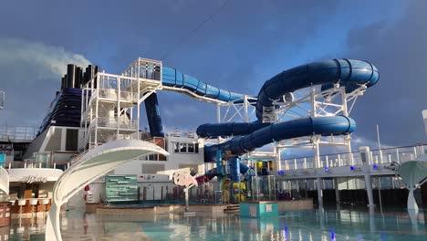 Ncl,-Norwegian-Bliss-Kreuzfahrtschiff-Pooldeck-Und-Rutschen-Nach-Regen-Mit-Schornstein