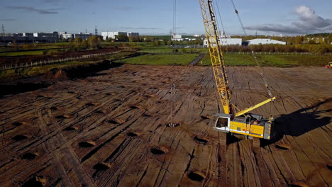 Aufsteigende-Luftaufnahme-Von-Maschinen,-Die-Auf-Der-Baustelle-Löcher-In-Den-Boden-Graben---Fundamentverdichtung