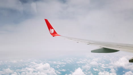 View-the-atmosphere-window-wing-of-a-Thai-Lion-Air-airplane-flight-in-sky-for-travel-transportation-on-holiday-at-Thailand