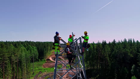 Primer-Plano-Aéreo-De-Los-Trabajadores-Que-Suben-A-La-Torre-De-Transmisión-Para-Construir-Nuevos-Y-Modernos-En-El-Bosque