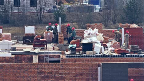 Close-Up-of-Builders-with-a-Red-Helmets-on-a-Building-Under-Construction