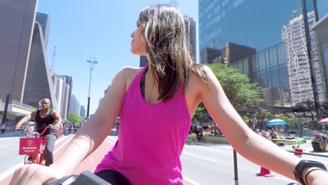 Bella-Joven-Morena-En-Bicicleta-Parada-En-El-Carril-Bici-De-La-Avenida-Paulista-En-Un-Hermoso-Día-Soleado