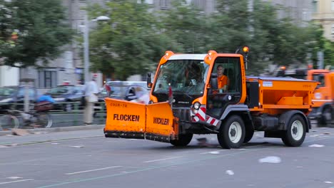 People-dodging-street-cleaning-machine-at-flea-market-in-Vienna