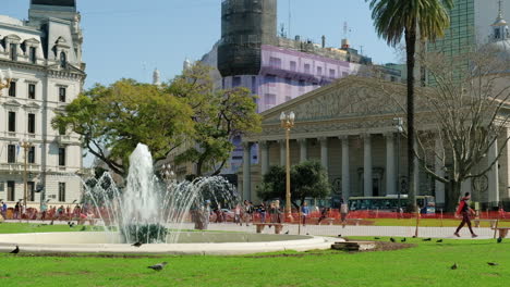 Fuente-Y-Gente-Caminando-En-La-Plaza-De-Mayo,-La-Catedral-De-Buenos-Aires-En-Segundo-Plano-Durante-El-Día