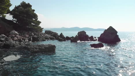 Low-drone-shot-through-sea-rock-in-sunny-day