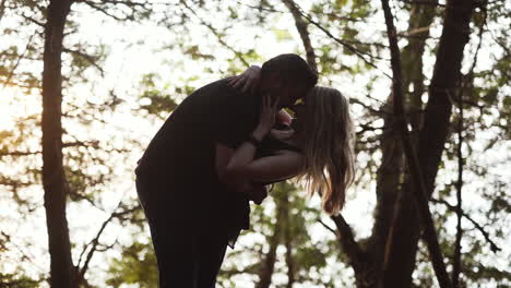 Pareja-Joven-Besándose-Y-Riéndose-Durante-La-Puesta-De-Sol-En-Un-Bosque