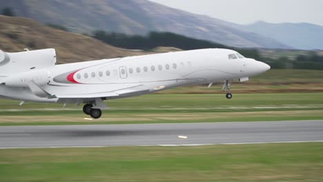 Private-jetplane-landing-at-Queenstown-Airport,-New-Zealand-with-mountains-in-background