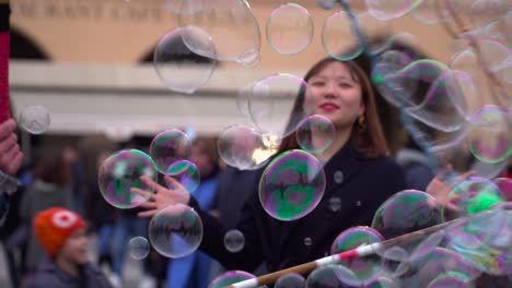 Schöne-Junge-Koreanerin,-Umgeben-Von-Seifenblasen-Des-Künstlers-Im-Stadtzentrum-Von-Prag