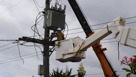 Ein-Elektroinstallateur,-Der-In-Einem-Kran-Arbeitet,-Um-Heruntergefallene-Stromleitungen-Von-Einem-Kürzlichen-Sturm-Zu-Reparieren