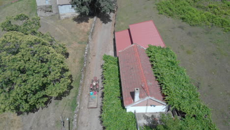 Aerial-tracking-shot-of-a-old-tractor-in-a-rural-village-in-the-north-of-Portugal