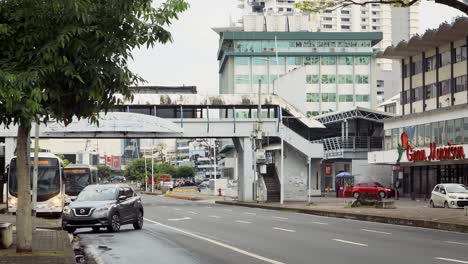 Taxis-and-buses-driving-on-the-road-down-a-high-street-in-Panama-City,-America