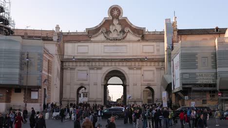 Northern-gate-of-the-Aurelian-Walls,-Entrance-of-people’s-square-of-Rome-with-tourists-crossing-street