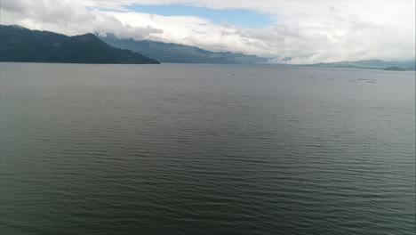 AERIAL:-Yojoa,-Panoramic-still-shot-of-lake-sorrounded-by-mountains-and-blue-sky,-Honduras