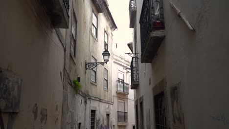 POV-walking-through-narrow-alleys-in-Alfama-area-in-Lisbon,-Portugal