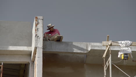 Khmer-construction-worker-on-a-roof-in-Phnom-Penh,-Cambodia