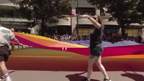 Empleados-Bancarios-Estadounidenses-Participando-En-El-Desfile-Lgbtq-De-Seattle,-Ondeando-Una-Bandera-Gigante-Del-Arcoíris