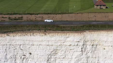 Toma-De-Perfil-Aéreo,-Seguimiento-Del-Tráfico-A-Lo-Largo-De-La-Carretera-De-La-Costa-Del-Acantilado-De-Tiza,-A259-Cerca-De-Brighton,-Reino-Unido