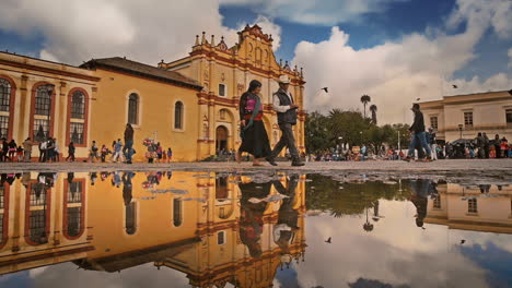 Hauptkathedrale-Und-Regenspiegelung-Auf-Dem-Boden-In-San-Cristobal-De-Las-Casas,-Chiapas,-Mexiko,-Erschossen-Passanten