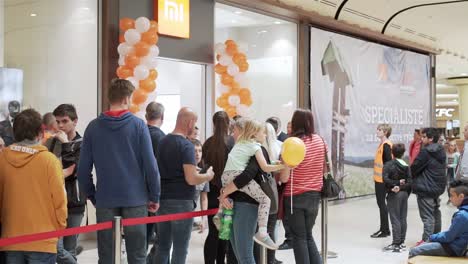 Crowd-of-people-waiting-for-Xiaomi-store-opening,-panning-right-shot