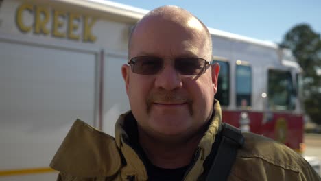 Bombero-Sonriendo-Para-Un-Retrato-En-Movimiento-Mientras-Está-Listo-Para-Responder-A-Emergencias