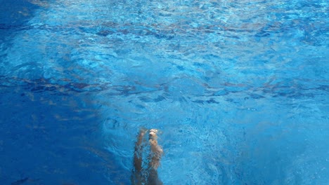 Una-Niña-Buceando-En-La-Piscina-En-Un-Día-De-Verano