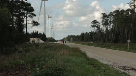 Una-Línea-De-Aerogeneradores-En-Un-Camino-De-Mazo-Con-árboles