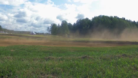 Los-Autos-De-Autocross-Compiten-En-Carreras-De-Aficionados-En-La-Pista-De-Tierra-En-Un-Día-Soleado-De-Verano,-Curvas-Planas,-Tiro-Amplio-Desde-Un-ángulo-Bajo