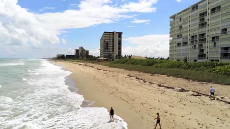 Aerial-view-of-ocean-in-Jensen-Beach,-Fl-with-people-walking-shore-side