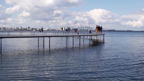 People-walking-along-the-infinite-bridge-during-a-calm-evening-in-Aarhus,-Denmark