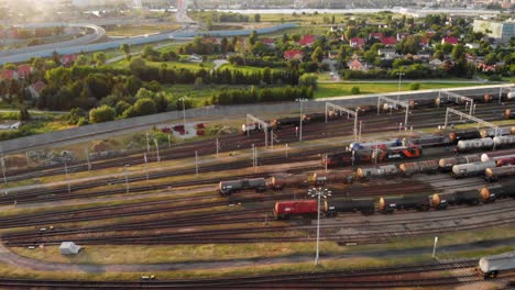 Toma-Aérea-Que-Muestra-Un-Gran-Depósito-De-Trenes-Con-Muchos-Trenes-De-Carga-Coloridos