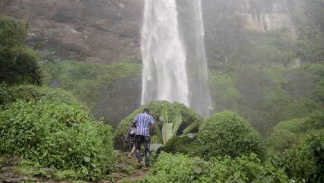 Un-Grupo-De-Hombres-Africanos-Haciendo-Senderismo-En-La-Base-De-Las-Cataratas-Sipi-En-Uganda